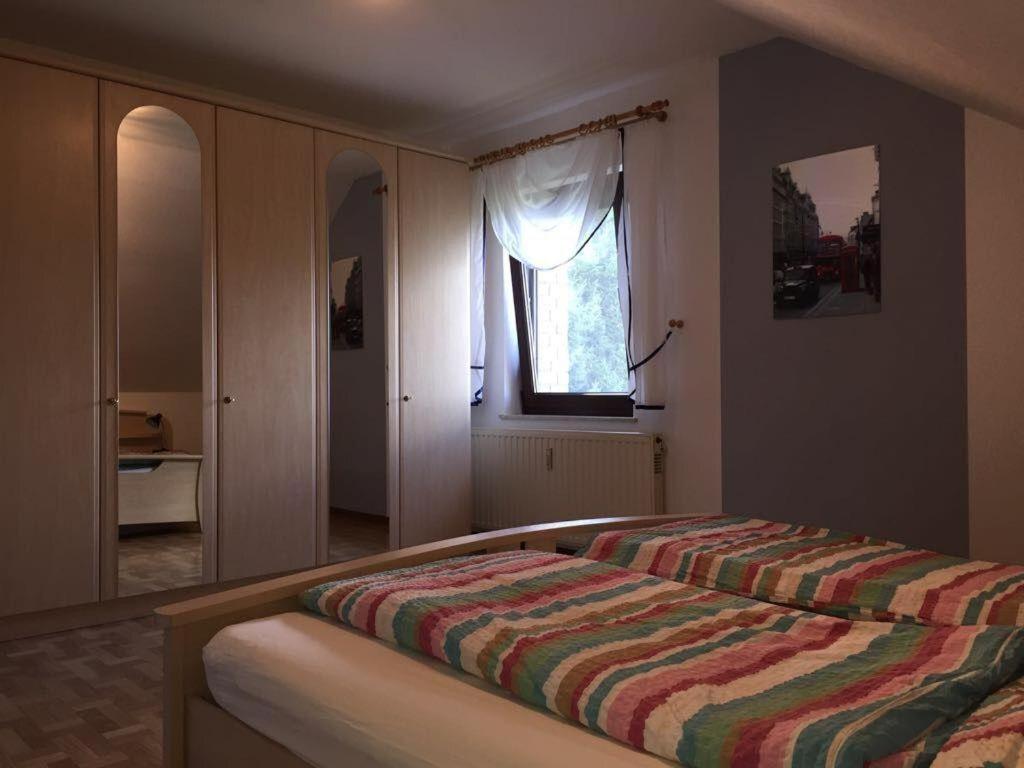 a bedroom with a bed with a striped blanket on it at Ferienwohnung-Freuen in Blankenheim
