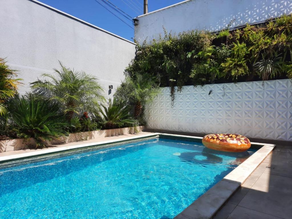 - une piscine avec un beignet installé à côté d'un bâtiment dans l'établissement Bela Casa Piscina Aquecimento Solar em Americana-SP, à Americana