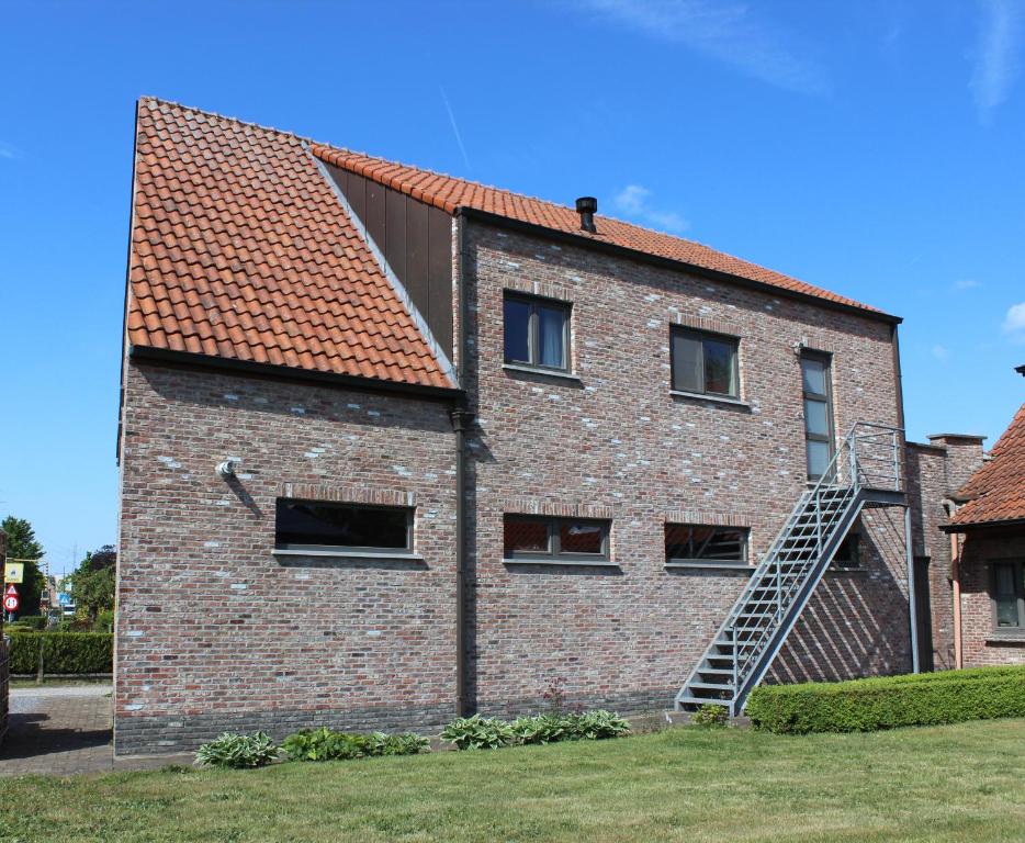 een bakstenen gebouw met een ladder aan de zijkant bij Vakantiewoning Op Den Briel in Lokeren