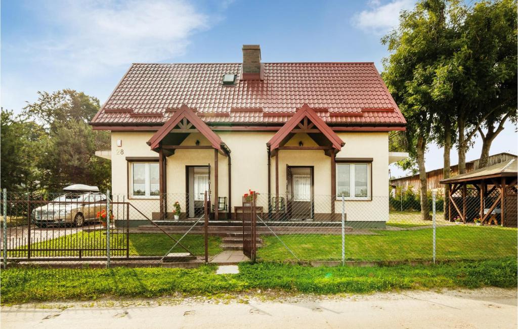 mały biały dom z czerwonym dachem w obiekcie Holiday Home Mielno Akacjowa Ii w mieście Mielno