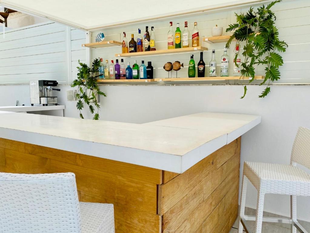 a kitchen with a counter with bottles on shelves at Hotel Apartamentos Marina Luz in Chipiona
