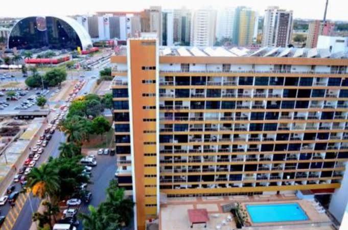 un gran edificio con piscina frente a una ciudad en Apart Hotel em Brasília - Garvey Park Hotel, en Brasilia