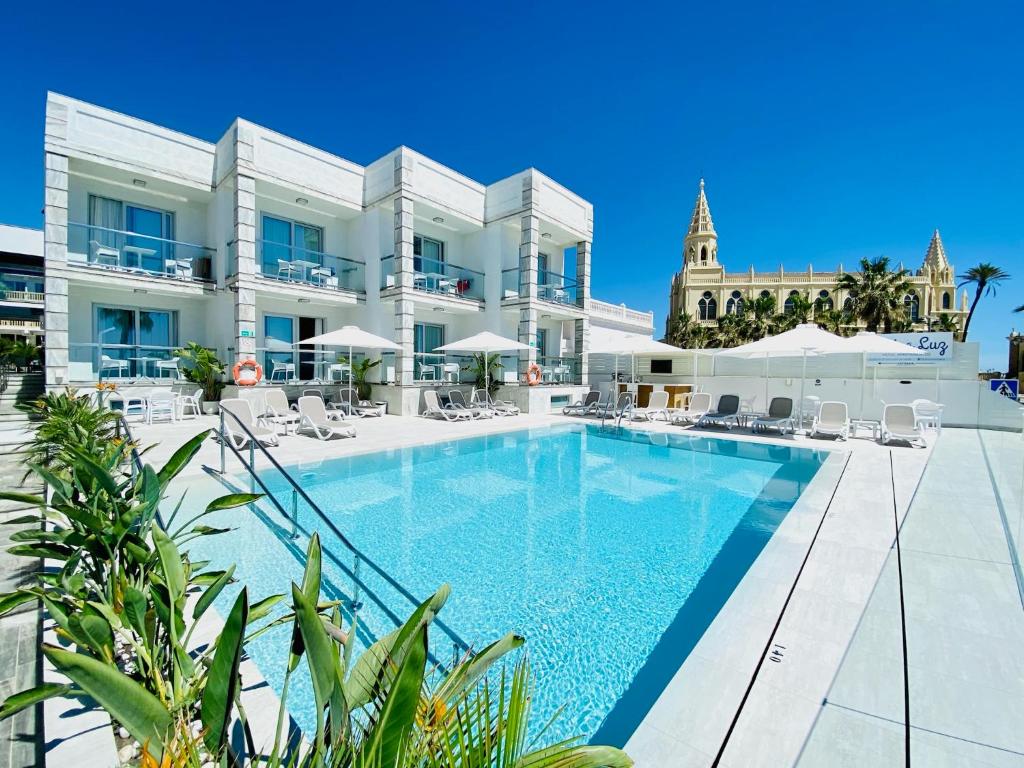 una piscina frente a un edificio en Hotel Apartamentos Marina Luz, en Chipiona
