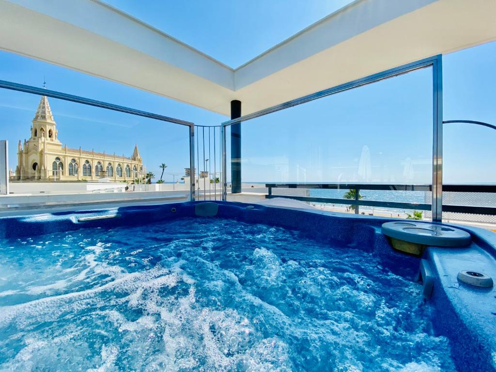 a hot tub in a room with a view of the building at Hotel Apartamentos Marina Luz in Chipiona