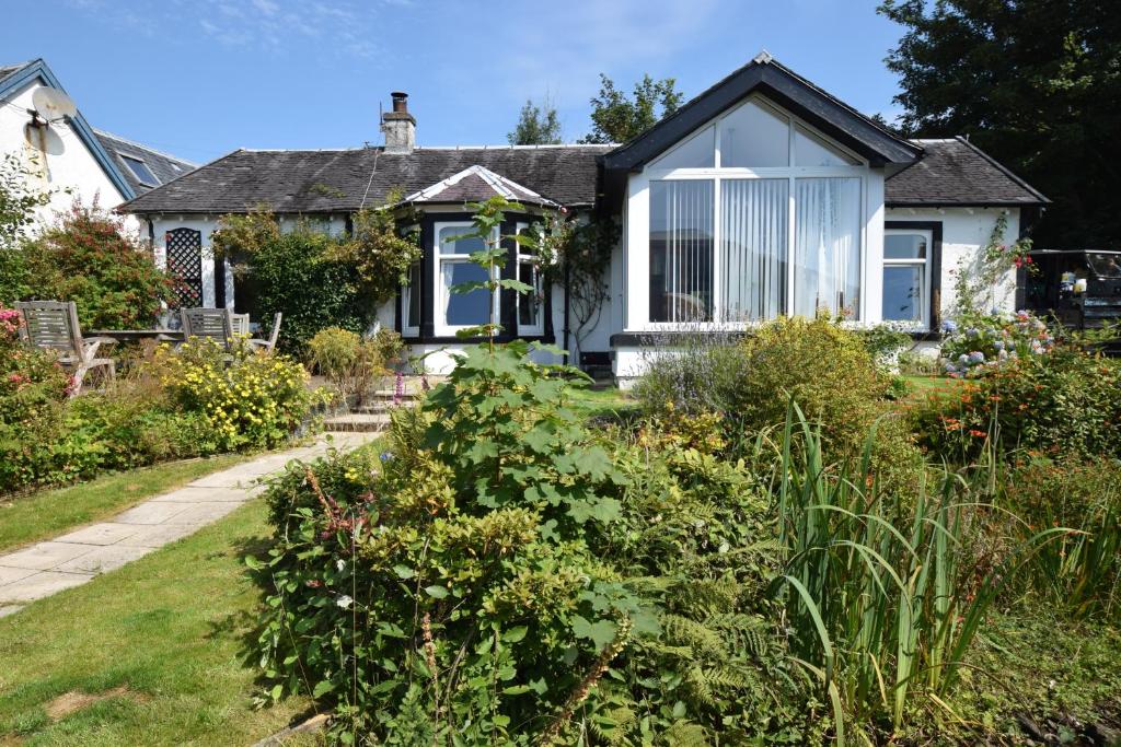 una casa con un jardín delante de ella en Ashburn Cottage, en Lochgoilhead