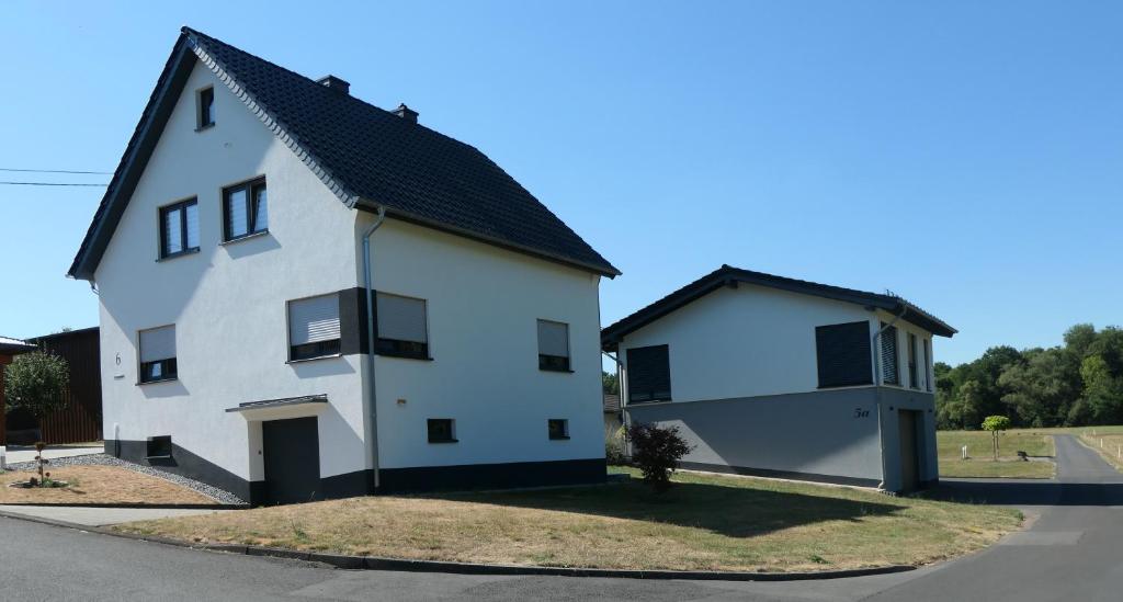 una casa blanca con techo negro en FEWO Hof Elbbachtal, en Westerburg