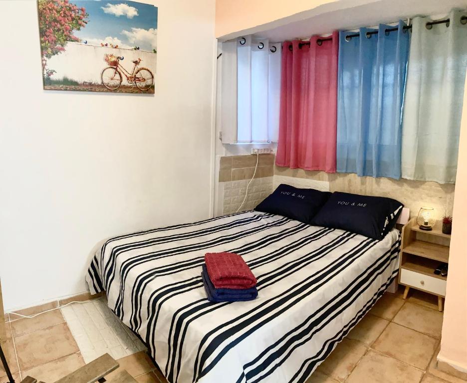 a bedroom with a bed with a red bag on it at Dotan's Boutique Apartments - By The Beach! in Tel Aviv