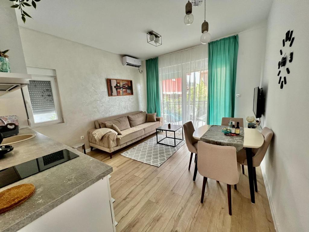 een keuken en een woonkamer met een tafel en een bank bij Apartments Tivat in Tivat