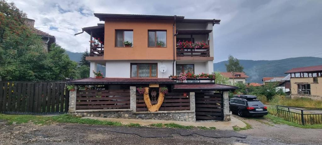 Una casa con un edificio con un cartel. en Guest House Markovi, en Govedartsi