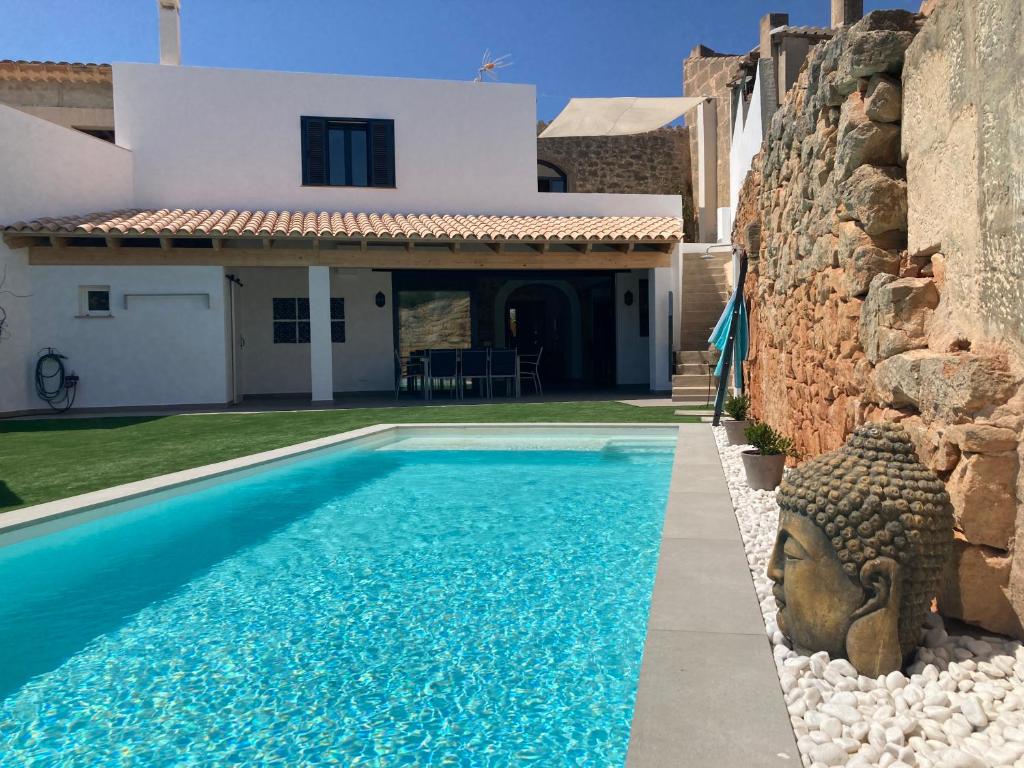 a swimming pool in front of a house at Can Roig in Ses Salines