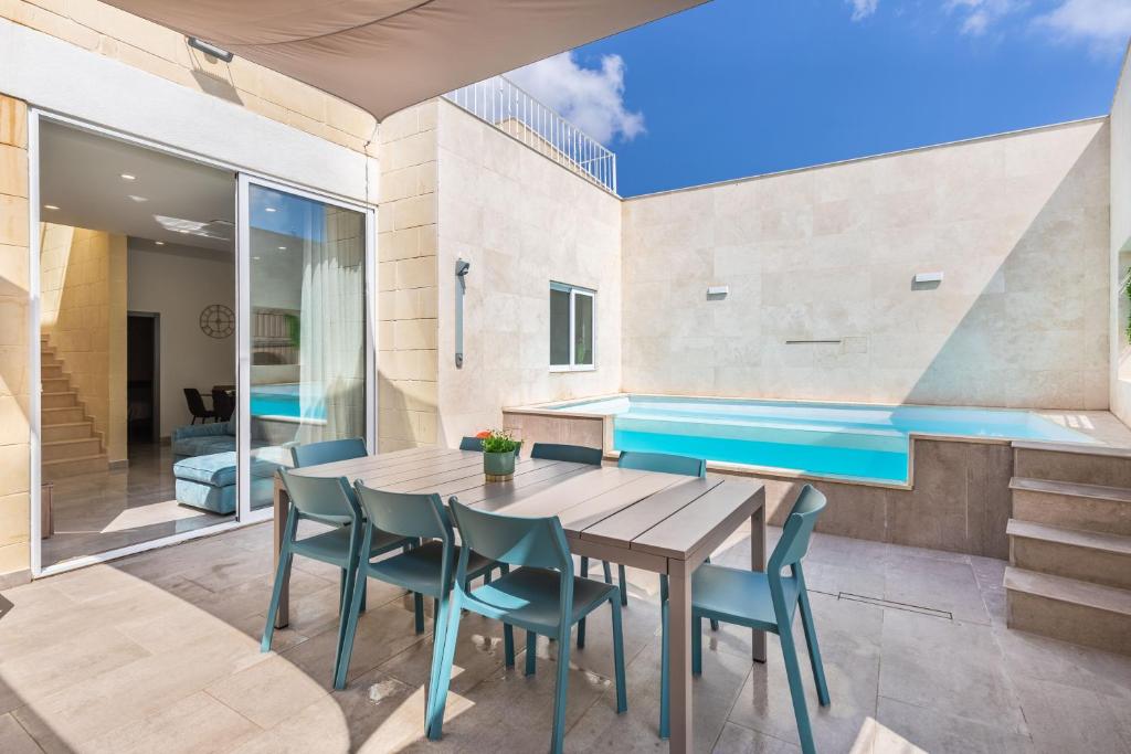 ein Esszimmer mit einem Holztisch und Stühlen in der Unterkunft Celestina Farmhouse in Xagħra