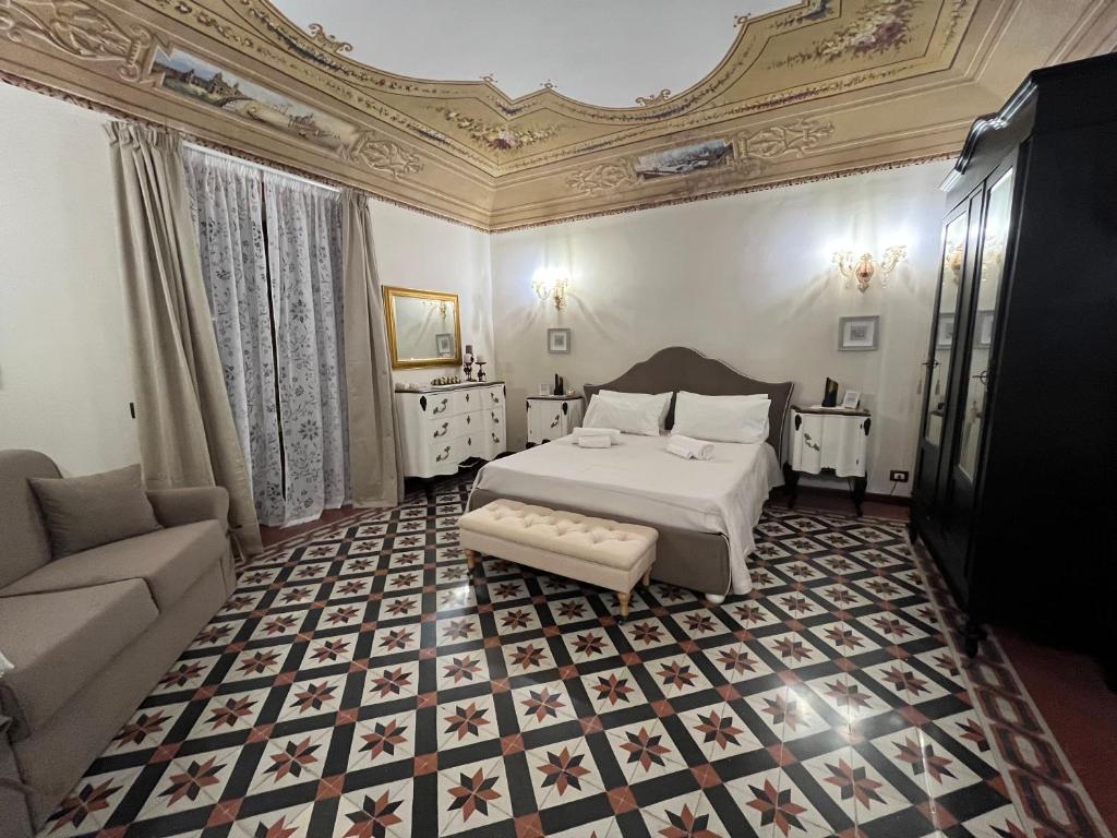 a bedroom with a bed and a couch at La piazza è mia in Cefalù
