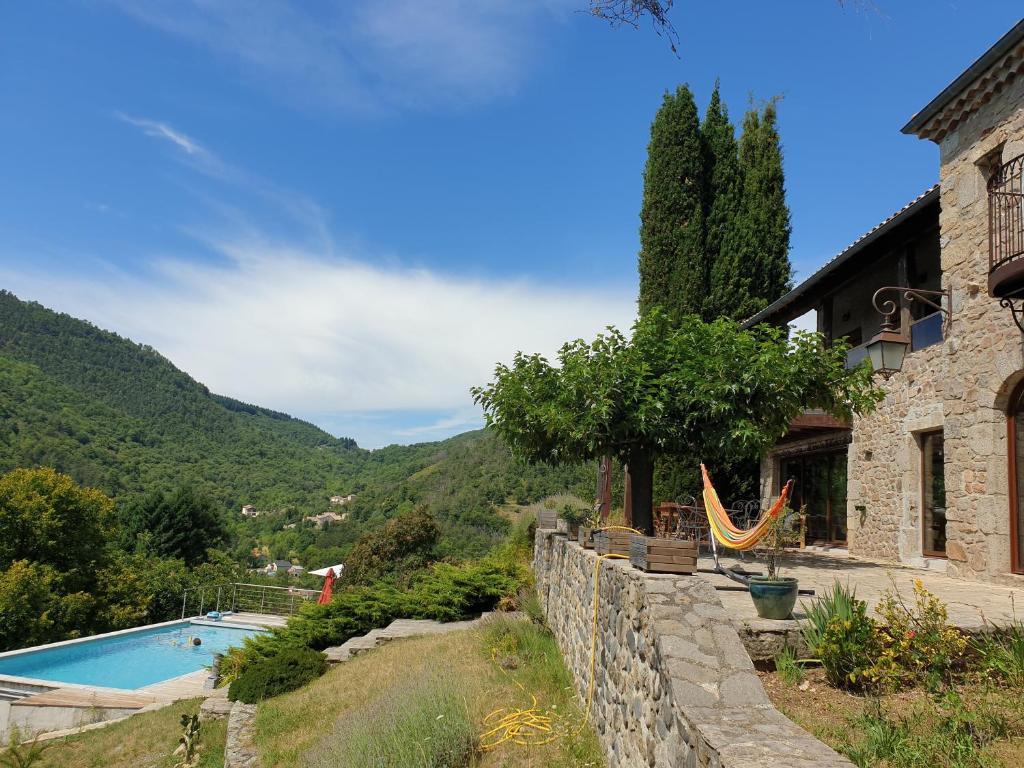 a villa with a swimming pool and a house at Là-Haut "Maison d'hôtes" in Antraigues