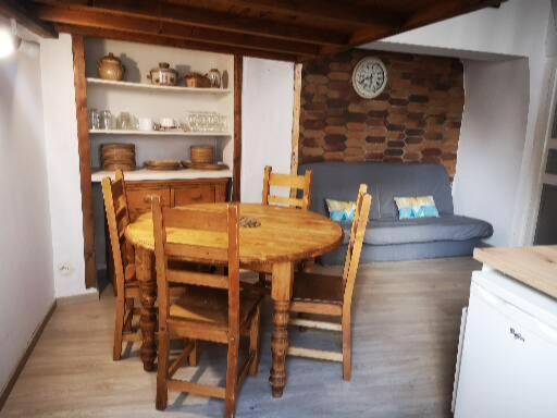 een eetkamer met een tafel en stoelen en een bank bij CAUTERETS Appart centre ville et calme idéal pr rando, ski et cure in Cauterets