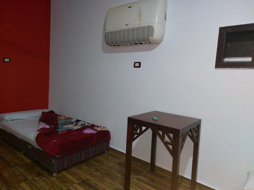 Habitación con cama, mesa y TV. en Dany ka, en Naj‘ al Maḩaţţah
