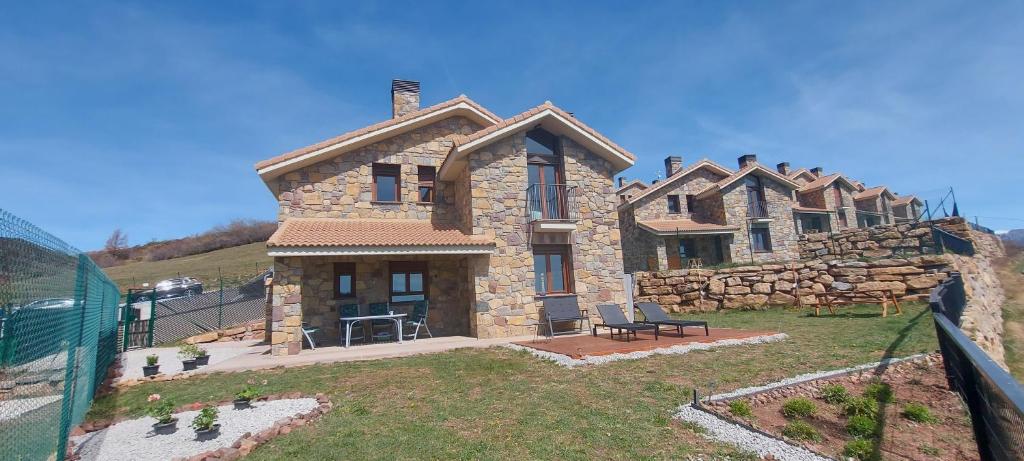 a large stone house with a fence in front of it at La Cabra Trepadora in Neril
