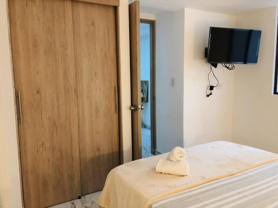a room with a bed with a wooden door at Apartaestudio moderno y acogedor con PARKING in Sabaneta