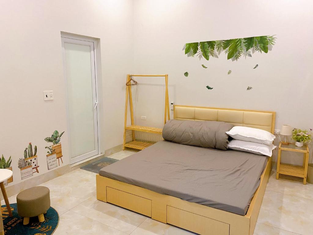 1 dormitorio con 1 cama con una planta en la pared en Thanh Sơn Homestay, en Cao Bằng