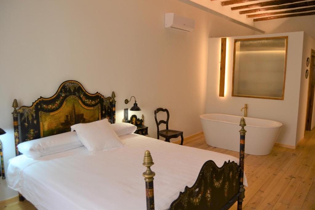a bedroom with a large bed and a bath tub at Lo Palauet de la Muralla in Balaguer
