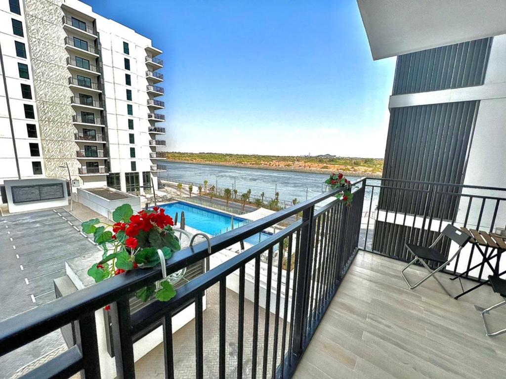 einen Balkon mit Pool und Blick auf das Wasser in der Unterkunft Yas Island canal 1- Formula 1, Entertainment, and Luxury Living! in Abu Dhabi