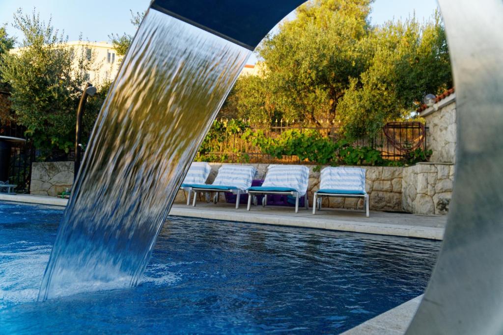 fontanna wodna w basenie z krzesłami w obiekcie Apartment Levarda with private hydromassage pool w Okrugu Gornjim