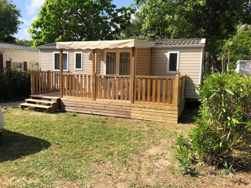 a mobile home with a porch and a deck at MOBIL HOME 6 personnes TOUT CONFORT in Saint-Cyprien