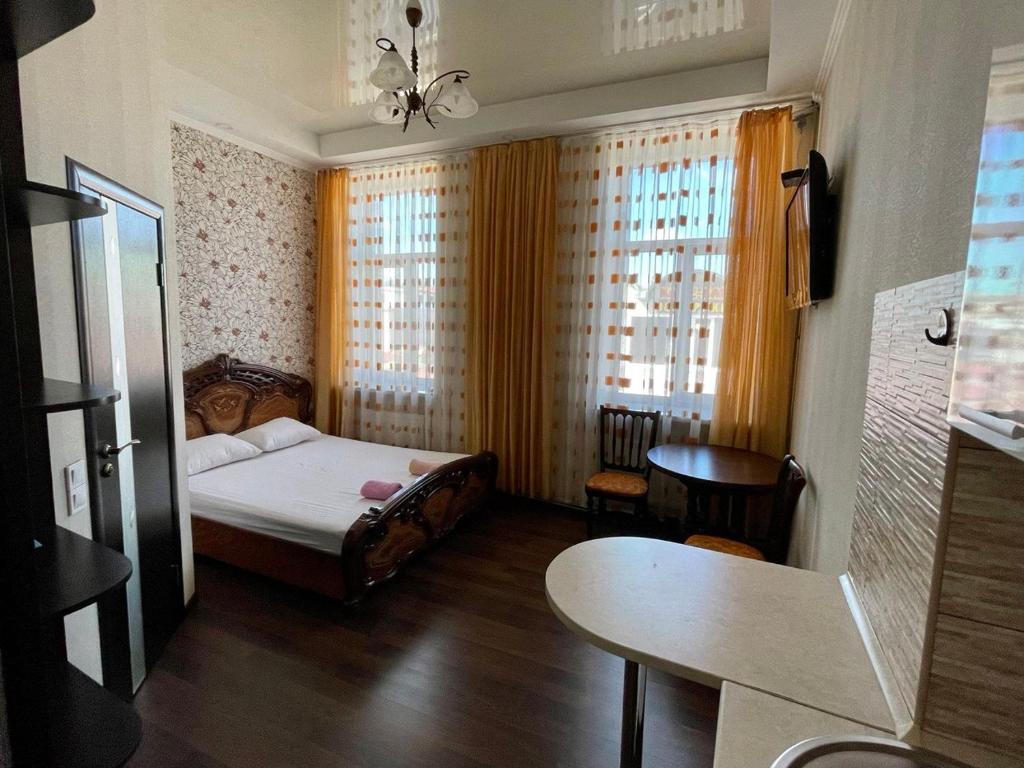 1 dormitorio con 1 cama, mesa y sillas en Apartment -біля Вокзалу-недалеко від Центру-Городоцька 151, en Leópolis