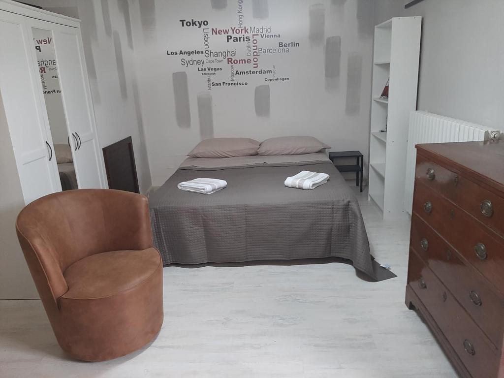 a bedroom with a bed with a chair and a dresser at DIGIO house in Camerata Picena