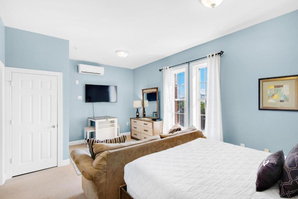 een slaapkamer met blauwe muren en een bed en een televisie bij Village of South Walton B377-G in Rosemary Beach