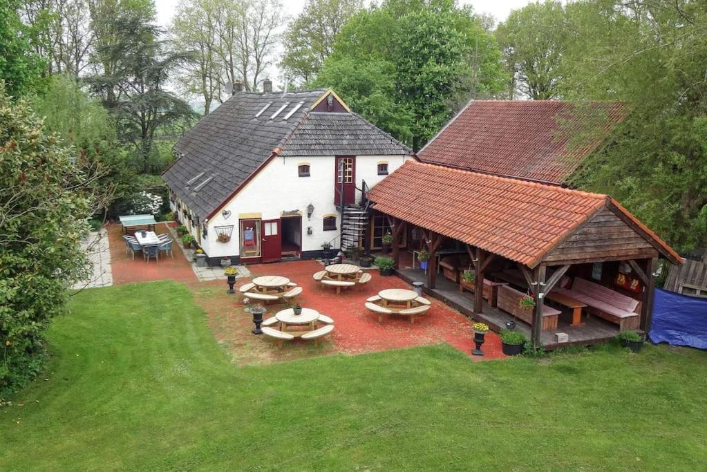 una vista aérea de una casa con un patio con mesas en De Linde, boerderij in Drenthe voor 15 tot 30 personen en Linde