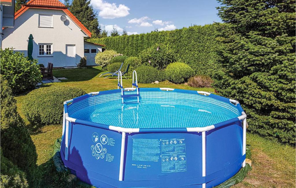 a swimming pool in the yard of a house at Cozy Home In Grzybowo With Kitchenette in Grzybowo