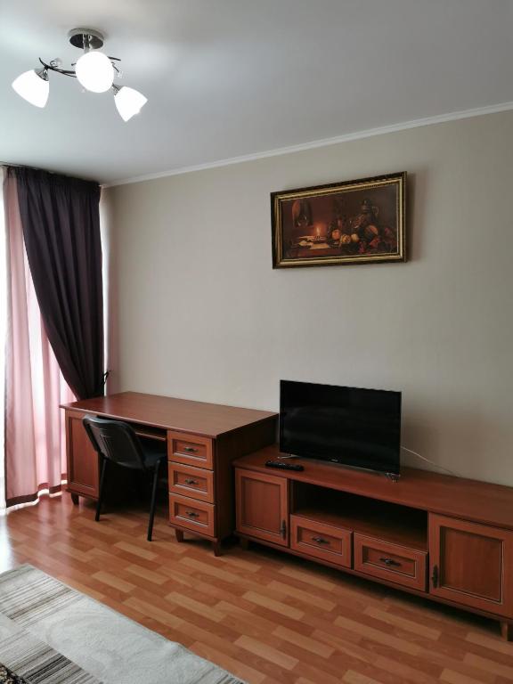 a living room with a desk and a television at 1 комнатная квартира в самом центре с видом на сквер in Kostanay