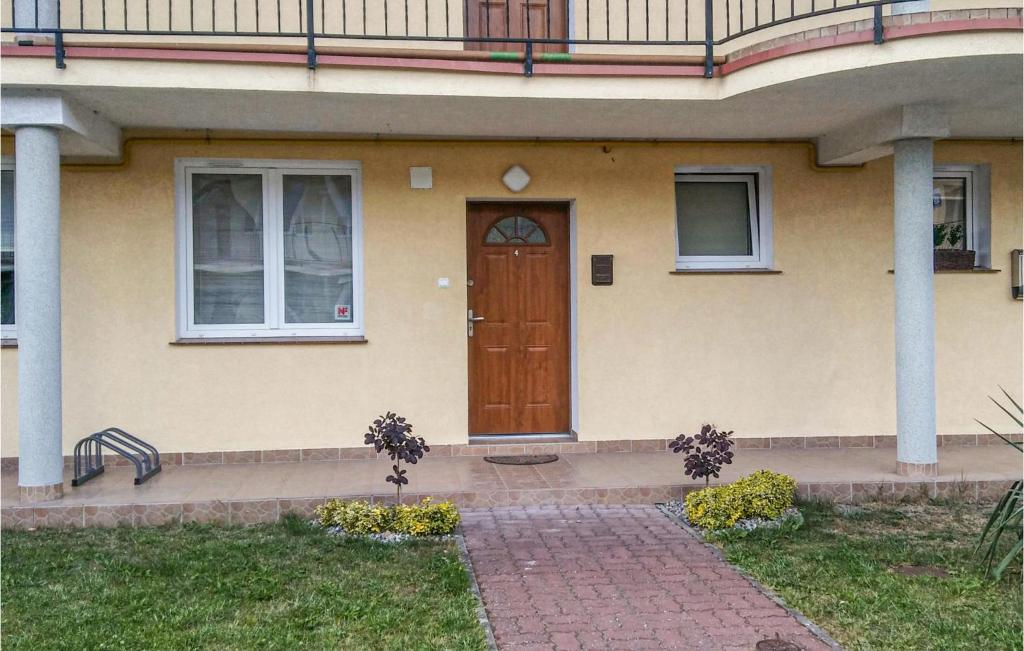 a house with a wooden door and a porch at Beautiful Apartment In Darlowo With 2 Bedrooms And Wifi in Darłowo