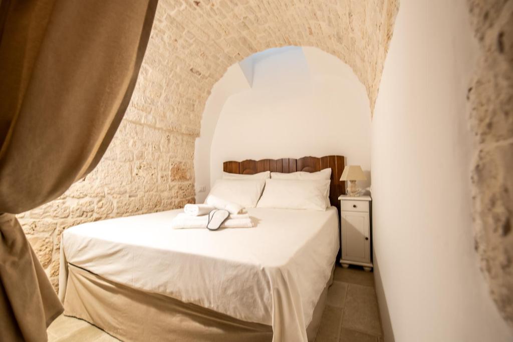 une chambre avec un lit sous une arche dans l'établissement Il trullo del Guelfo, à Alberobello