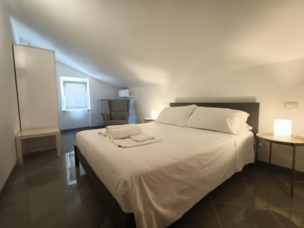 - une chambre avec un grand lit blanc et 2 serviettes dans l'établissement Tenuta Marina B&B, à Torino di Sangro