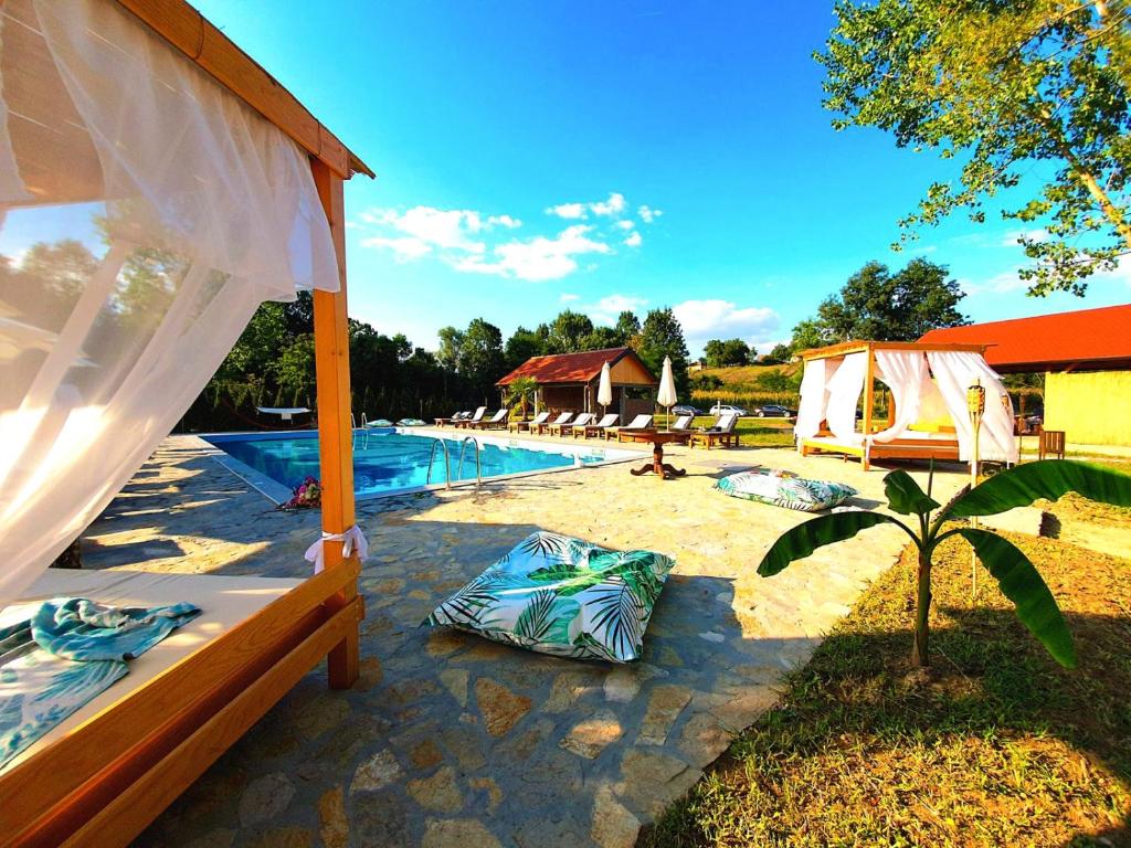 a swimming pool with a bed and a tent at Imanje Lotus Garden in Šabac