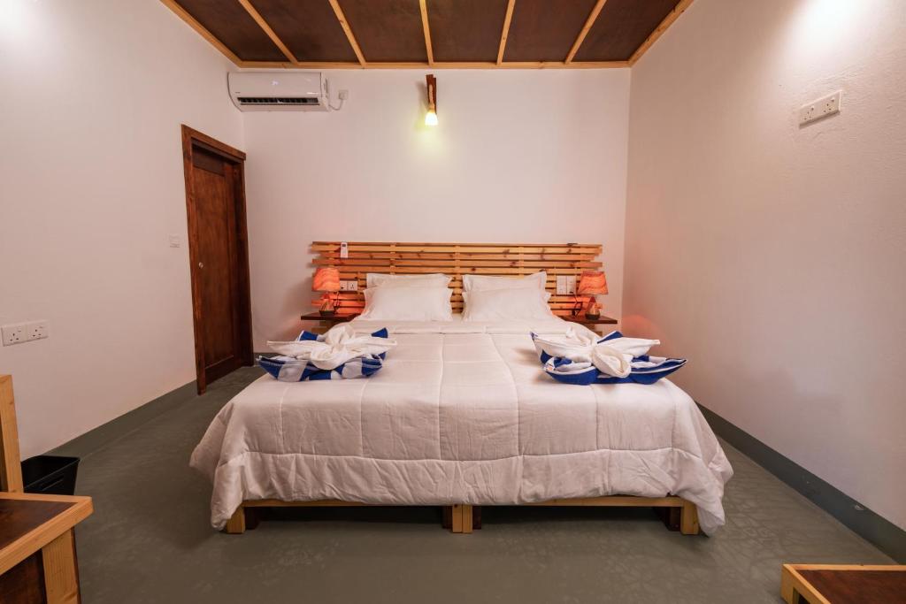 a bedroom with a large bed with blue and white pillows at Vacanza Mathiveri in Mathiveri