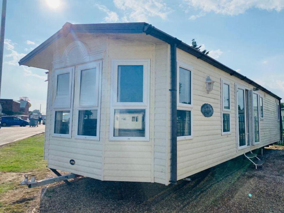 una casa pequeña está sentada en la hierba en Luxury 2 Bedroom 2 bathroom Caravan-small sofa 1 pers en Saint Osyth