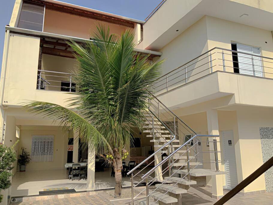 a palm tree in front of a house with a staircase at Pousada Recanto Solarium in Itanhaém