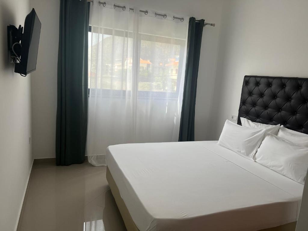 ein Schlafzimmer mit einem weißen Bett und einem Fenster in der Unterkunft Tarrafal Guest House in Tarrafal