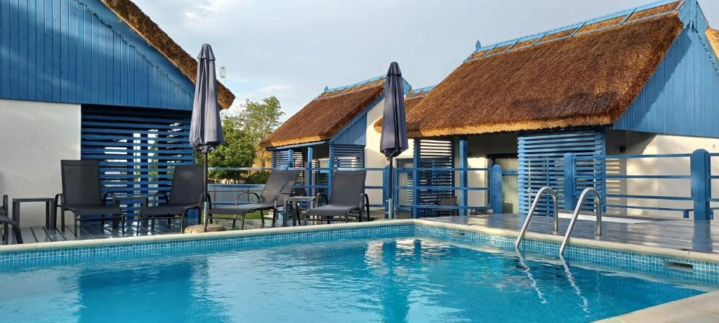 una piscina con sillas y una casa en Déjà Blue - ADULT ONLY en Sfântu Gheorghe