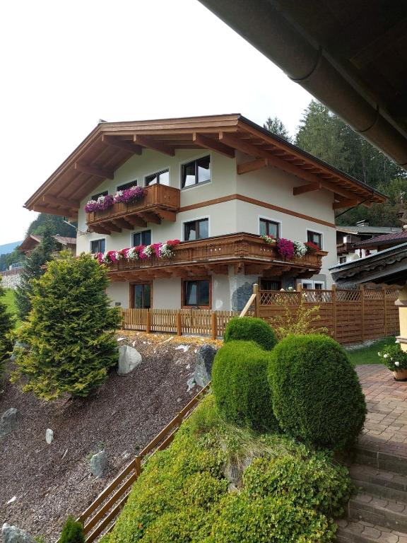 a house with a balcony with flowers on it at Ferienwohnung Julia Kröll in Mittersill