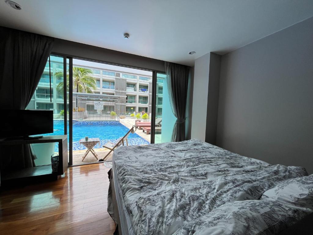 1 dormitorio con cama y vistas a la piscina en Instagramable pool studio 1 bedroom in Bangtao, en Phuket