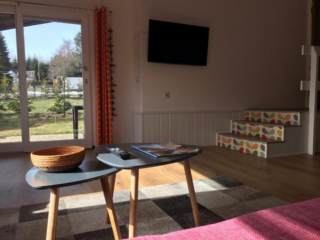 a living room with a table and a tv at Modernes Ferienhaus Willingen in Willingen