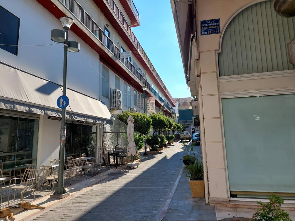 une rue vide avec des tables et des chaises à l'extérieur des bâtiments dans l'établissement PETMEZA APARTMENT 1 by DIMITROPOULOS, à Aigio
