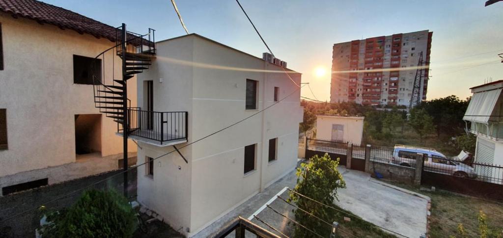 a view of a building with the sunset in the background at ALIKO's peaceful house, close to bus terminal in Tirana