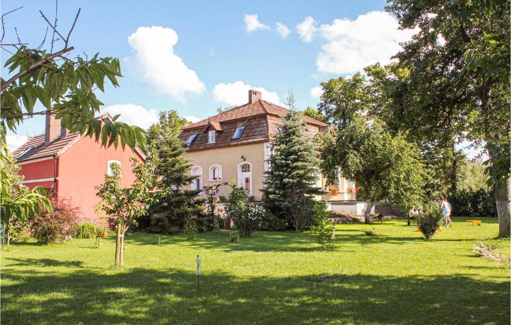 een groot huis in een tuin met bomen en gras bij Amazing Home In Nowe Warpno With Kitchen in Nowe Warpno