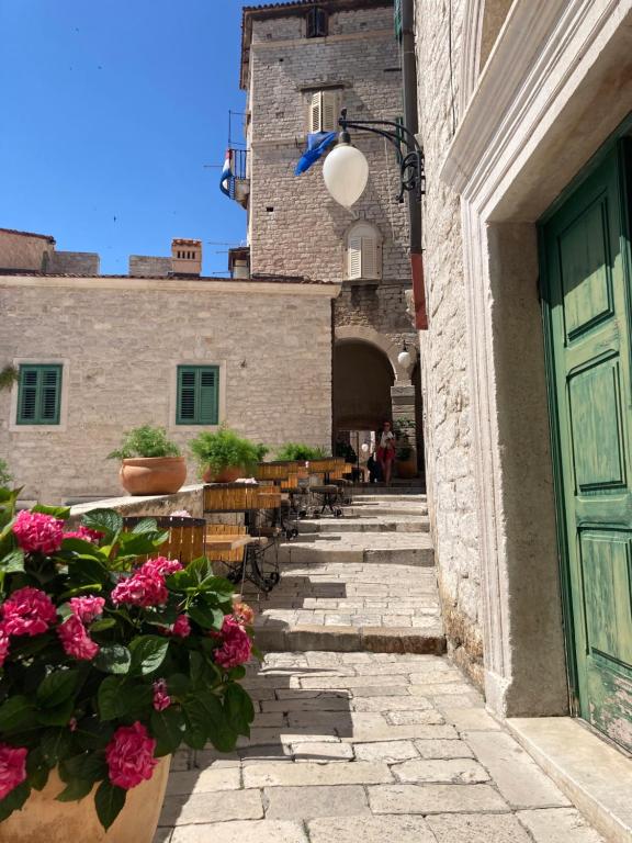a walkway with flowers and chairs and a door at TheRoom in Šibenik