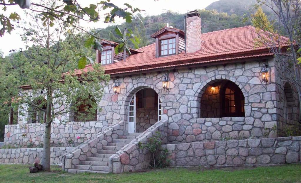 a stone house with a red roof at La Aguada Hotel Boutique de Montana in Coneta