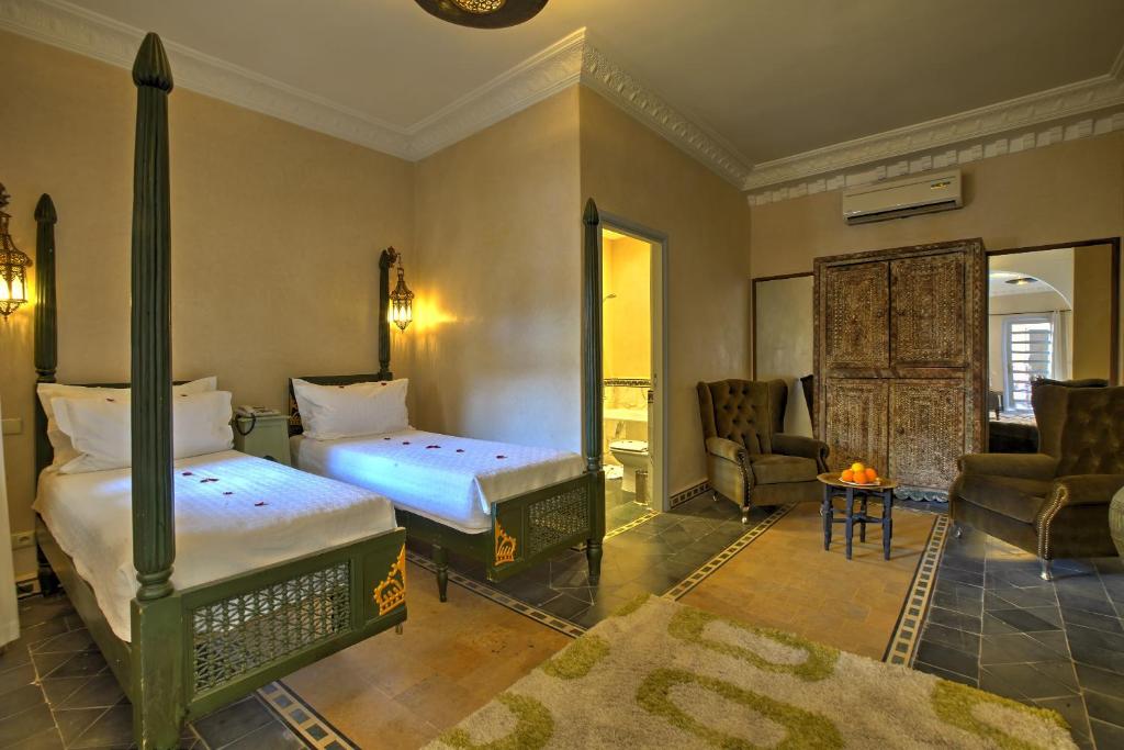 a bedroom with two beds and a living room at Ksar Anika Boutique Hotel & Spa in Marrakech